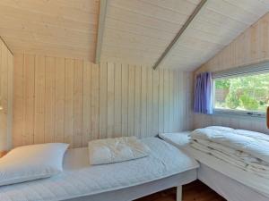 Duas camas num pequeno quarto com uma janela em Holiday Home Raafael - 175m from the sea in Djursland and Mols by Interhome em Knebel
