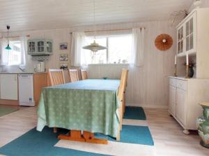 una sala da pranzo con tavolo e una cucina di Holiday Home Axilen - 1km from the sea in Djursland and Mols by Interhome a Grenå