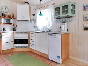 una cucina con armadi bianchi e lavandino di Holiday Home Axilen - 1km from the sea in Djursland and Mols by Interhome a Grenå