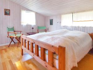 una camera con un grande letto e due sedie di Holiday Home Axilen - 1km from the sea in Djursland and Mols by Interhome a Grenå