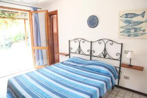sypialnia z łóżkiem z niebiesko-białym kocem w obiekcie Villa Olivastro w mieście Torre delle Stelle