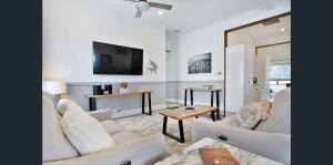 een woonkamer met witte meubels en een flatscreen-tv bij MJ's 2 bedroom luxury style apartment in Ipswich