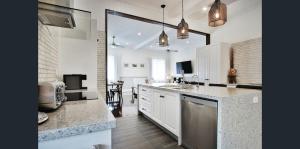 een keuken met witte kasten en een aanrecht bij MJ's 2 bedroom luxury style apartment in Ipswich