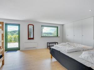 um quarto branco com uma cama grande e janelas em Holiday Home Gertje in SE Jutland by Interhome em Bryrup