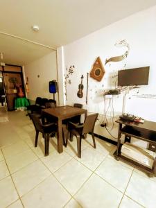 a living room with a table and a piano at Oasis de Tolú in Tolú