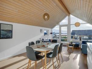 una sala da pranzo e un soggiorno con tavolo e sedie. di Holiday Home Gudserk - 50m from the sea in Djursland and Mols by Interhome a Rønde