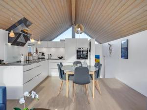 una cucina e una sala da pranzo con tavolo e sedie di Holiday Home Gudserk - 50m from the sea in Djursland and Mols by Interhome a Rønde