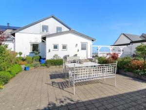 una casa blanca con un patio delante en Holiday Home Stavn - 20m from the sea in Djursland and Mols by Interhome, en Glesborg