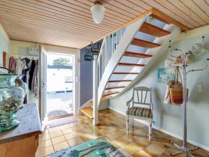 Una habitación con una escalera y una silla en una habitación en Holiday Home Stavn - 20m from the sea in Djursland and Mols by Interhome, en Glesborg