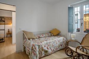 a bedroom with a bed with a floral bedspread at Apartamento Essence by Solset in Frigiliana