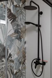 a black stand up shower in front of a wall at Apartamento Essence by Solset in Frigiliana