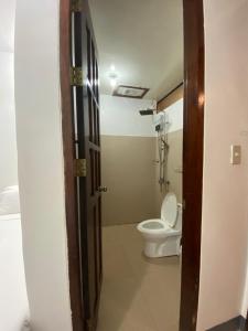 uma casa de banho com WC e uma porta aberta em WILDROSE INN em El Nido