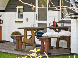 einem Picknicktisch aus Holz und einer Bank auf einer Terrasse in der Unterkunft Holiday Home Indira - 500m from the sea in Djursland and Mols by Interhome in Ørsted