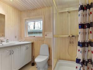 La salle de bains est pourvue de toilettes, d'un lavabo et d'une douche. dans l'établissement Holiday Home Teofilka - 200m from the sea in NE Jutland by Interhome, à Sæby