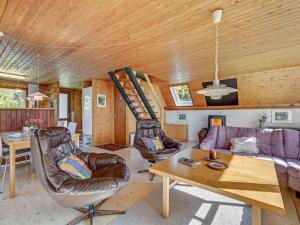 ein Wohnzimmer mit einem Sofa und einer Holzdecke in der Unterkunft Holiday Home Indira - 500m from the sea in Djursland and Mols by Interhome in Ørsted