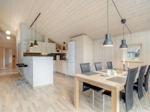 a kitchen and dining room with a table and chairs at Holiday Home Femke - 250m to the inlet in NE Jutland by Interhome in Storvorde