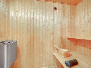 a sauna with a wooden wall and a bucket on a shelf at Holiday Home Femke - 250m to the inlet in NE Jutland by Interhome in Storvorde