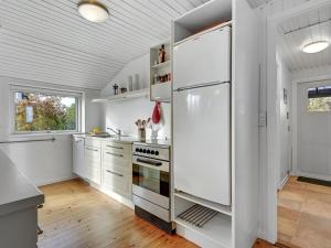 eine Küche mit weißen Geräten und einem großen Kühlschrank in der Unterkunft Holiday Home Joon - 300m from the sea in Djursland and Mols by Interhome in Ørsted