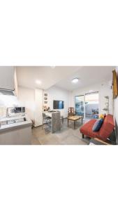 eine Küche und ein Wohnzimmer mit einem Sofa und einem Tisch in der Unterkunft Koukaki Home in Athen