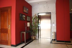 a hallway with red walls and a door at Hotel Mulhacen in Guadix