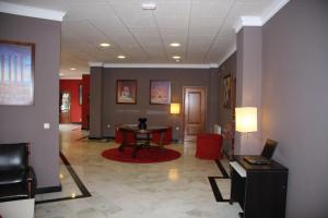 un couloir avec une table et des chaises dans un bâtiment dans l'établissement Hotel Mulhacen, à Guadix