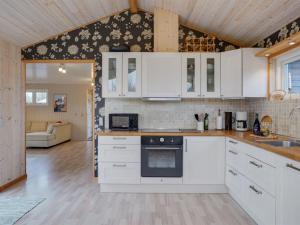 een keuken met witte kasten en een fornuis bij Holiday Home Nelda - 300m to the inlet in NE Jutland by Interhome in Storvorde