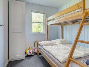 een slaapkamer met 2 stapelbedden en een raam bij Holiday Home Nelda - 300m to the inlet in NE Jutland by Interhome in Storvorde