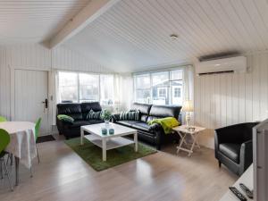 uma sala de estar com sofás pretos e uma mesa em Holiday Home Cosima - 130m to the inlet in NE Jutland by Interhome em Storvorde