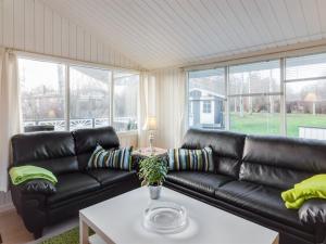 uma sala de estar com um sofá de couro preto em Holiday Home Cosima - 130m to the inlet in NE Jutland by Interhome em Storvorde