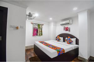 um quarto com uma cama num quarto branco em FabExpress Royal Oak em Calcutá