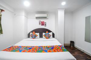 um quarto com uma cama com um cobertor colorido em FabExpress Royal Oak em Calcutá