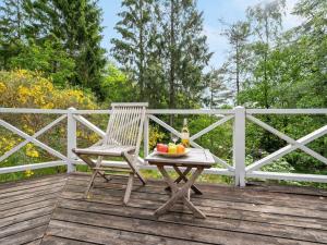 a wooden chair sitting on a wooden deck with a bowl of fruit at Holiday Home Belenda in SE Jutland by Interhome in Silkeborg