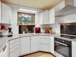 cocina blanca con armarios blancos y ventana en Holiday Home Toska in SE Jutland by Interhome, en Silkeborg