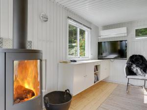 a living room with a fireplace and a tv at Holiday Home Self - 400m to the inlet in The Liim Fiord by Interhome in Løgstrup