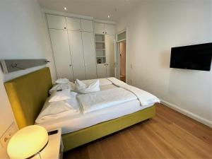 ニュルンベルクにあるDeluxe Apartments Christina 120 m² im Design Hotel Vosteenのベッドルーム1室(ベッド1台、壁にテレビ付)