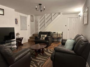 een woonkamer met lederen meubels en een trap bij spacious 2 bedroom house in Shotton