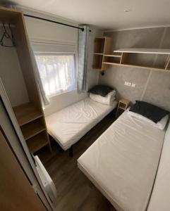 a small room with two beds and a window at Superbe Mobil home 6-8 personnes (57) in Saint-Jean-de-Monts