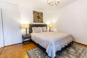 Schlafzimmer mit einem Bett und einem Kronleuchter in der Unterkunft Perfect apartment Montreux centre - Lake View in Montreux