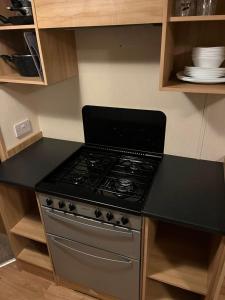 a kitchen with a stove and a counter top at Golden Palm Resort PG163 in Chapel Saint Leonards