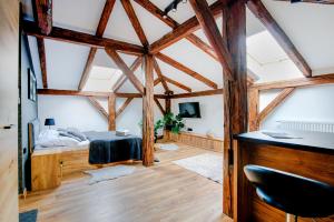 um quarto com uma cama num quarto com vigas de madeira em VIP Apartamenty em Rzeszów