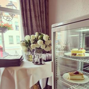 una mesa con un pastel y un jarrón de flores en Nordischer Hof, en Krakow am See