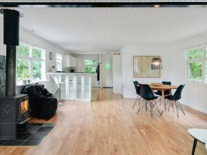 een woonkamer met een open haard en een tafel en stoelen bij Holiday Home Hilde - 1-7km from the sea in NE Jutland by Interhome in Sæby
