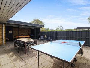 un patio con mesa de ping pong y sillas en Holiday Home Kiowa - 100m from the sea in Djursland and Mols by Interhome en Allingåbro