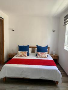 a bedroom with a large bed with blue and red sheets at Serenity apartments in Trou aux Biches