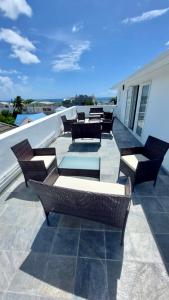 a group of chairs and tables on a patio at Serenity apartments in Trou aux Biches