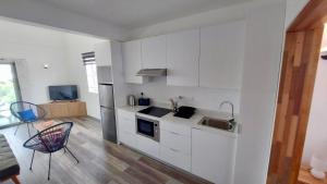 a white kitchen with a sink and a stove at Serenity apartments in Trou aux Biches