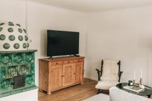 a living room with a flat screen tv on a wooden cabinet at Charming chalet with sauna + views! in Bad Gastein
