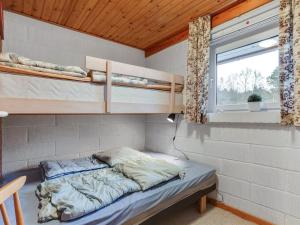 um pequeno quarto com uma cama e uma janela em Holiday Home Anemarie - 450m from the sea in NE Jutland by Interhome em Sæby