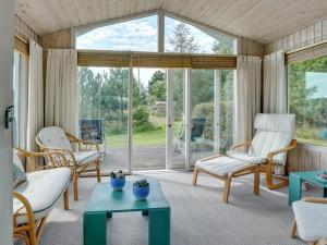 een woonkamer met meubilair en een groot raam bij Holiday Home Glum - 300m from the sea in NE Jutland by Interhome in Sæby