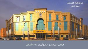 a large yellow building with cars parked in front of it at Innyar Hotel - فندق انيار in Riyadh